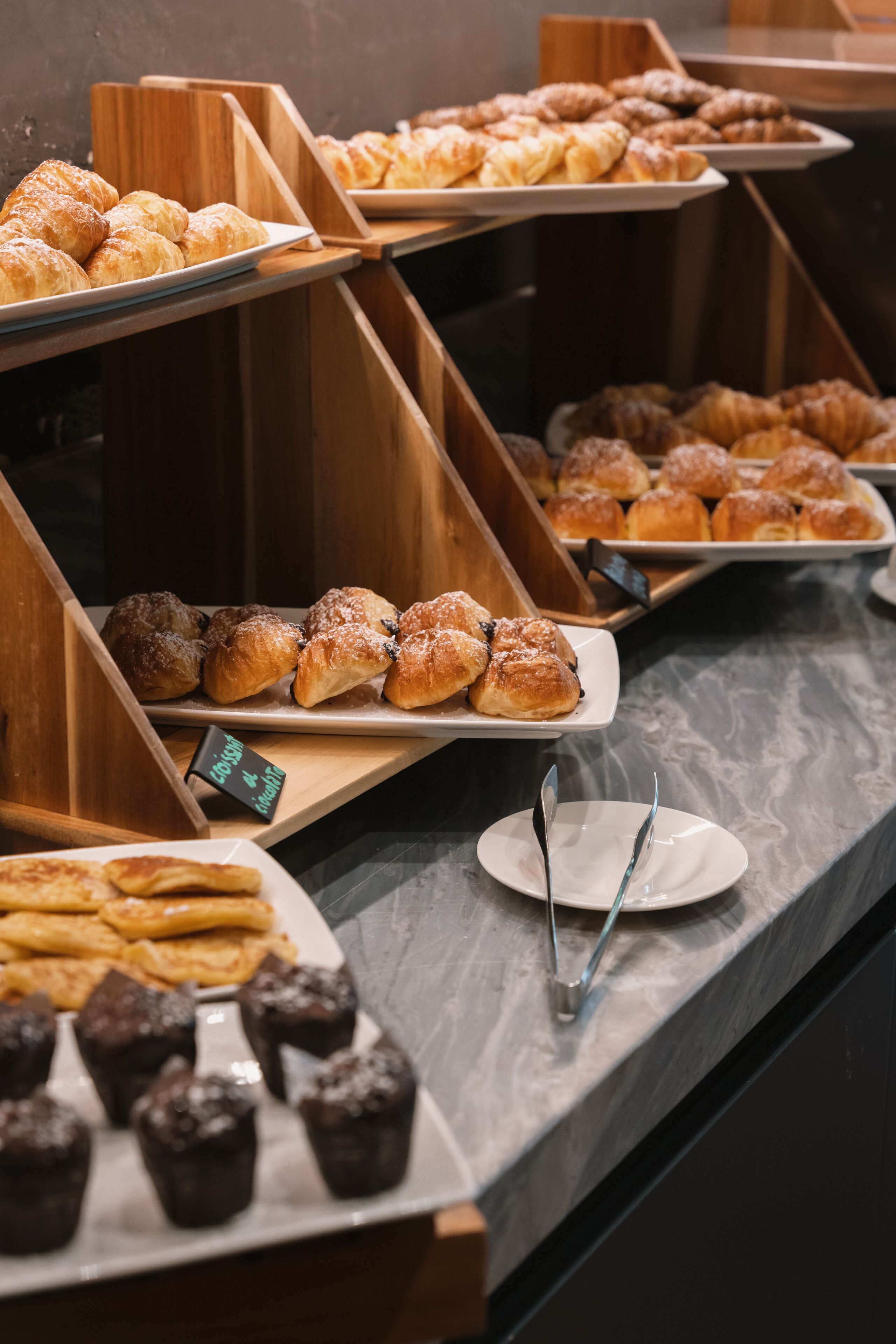 Un buffet con diversi prodotti da forno, come pasticcini e muffin.
