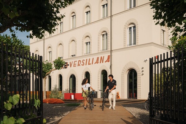 Un bâtiment doté de fenêtres en arc de cercle et d’une enseigne indiquant « VERSILIANA 4 ».