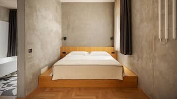 Un dormitori modern amb un llit de fusta, una finestra gran amb cortines, i un bany a la vista amb banyera.