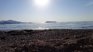 Une plage de galets et un ciel dégagé.