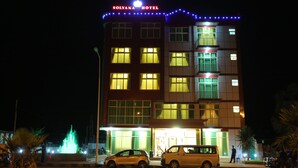 A hotel building with illuminated windows and a sign reading "Solyana Hotel".