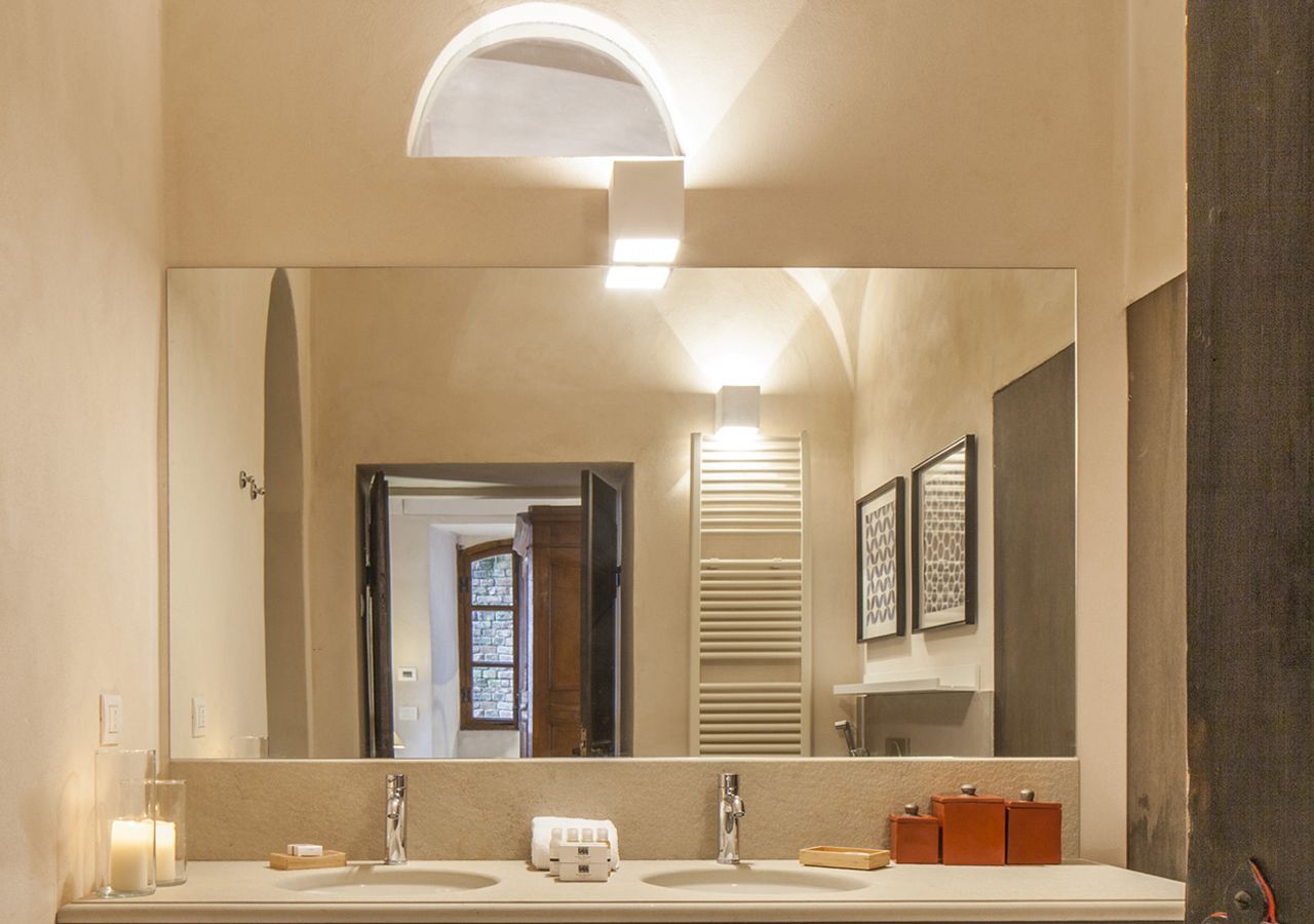 A bathroom with a large mirror, two sinks, and a vanity.