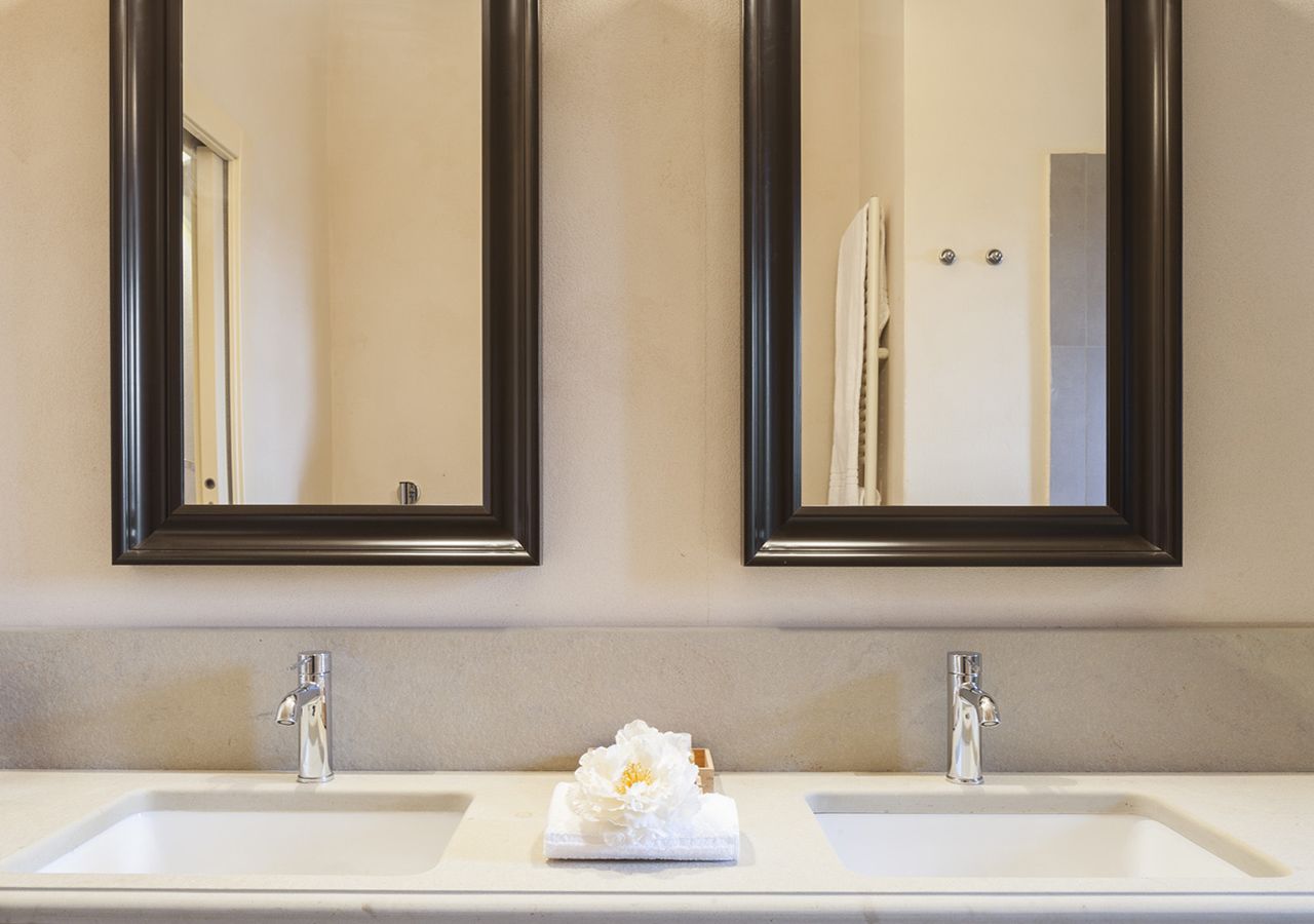 Un baño con dos lavamanos, cada uno con un espejo encima.