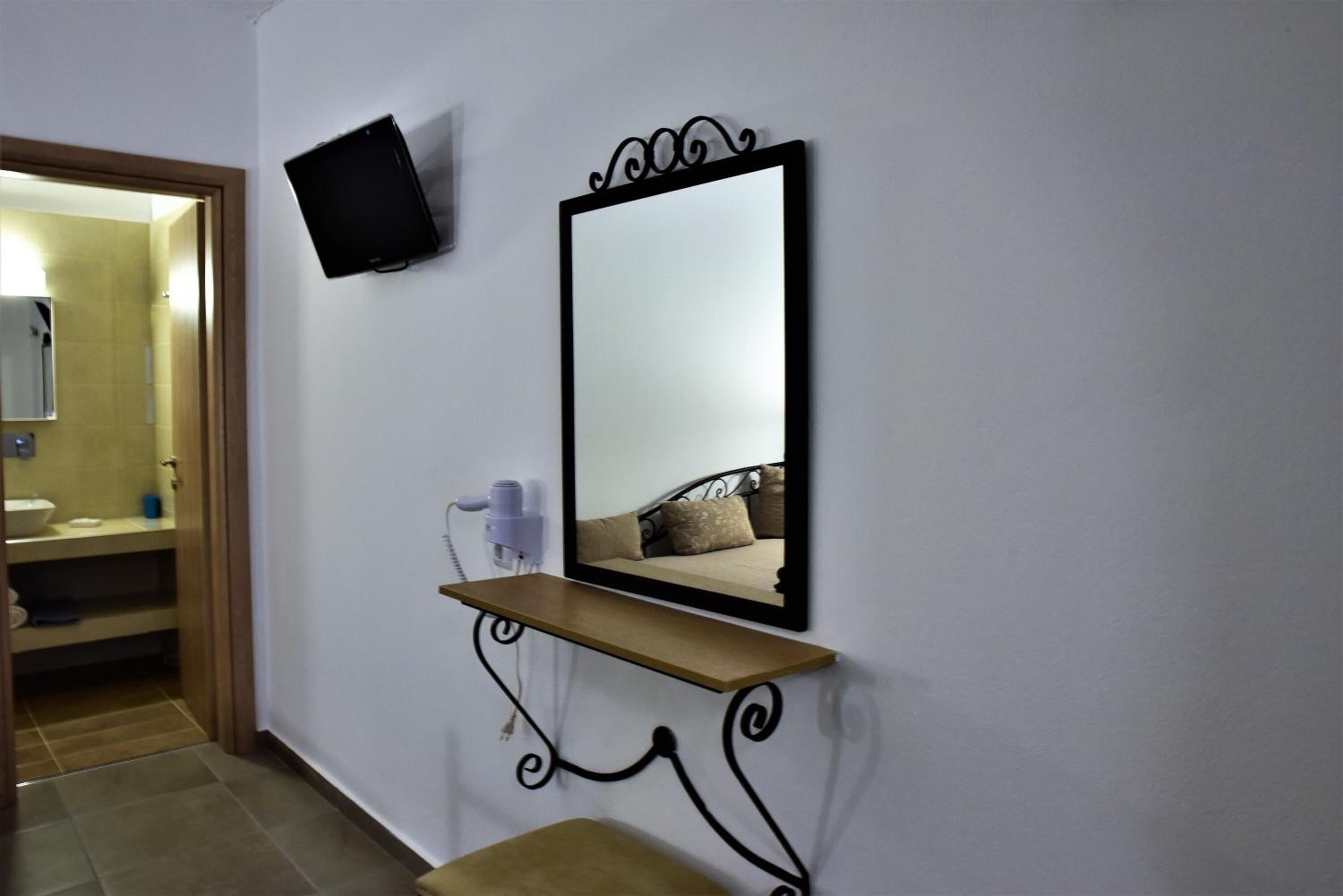 A bathroom with a mirror, a shelf, and a hairdryer.