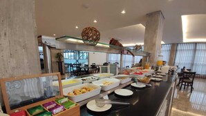 A buffet with various food items and a glass display case with packaged goods. - Summit Suítes Hotel Caçapava (Cacapava)