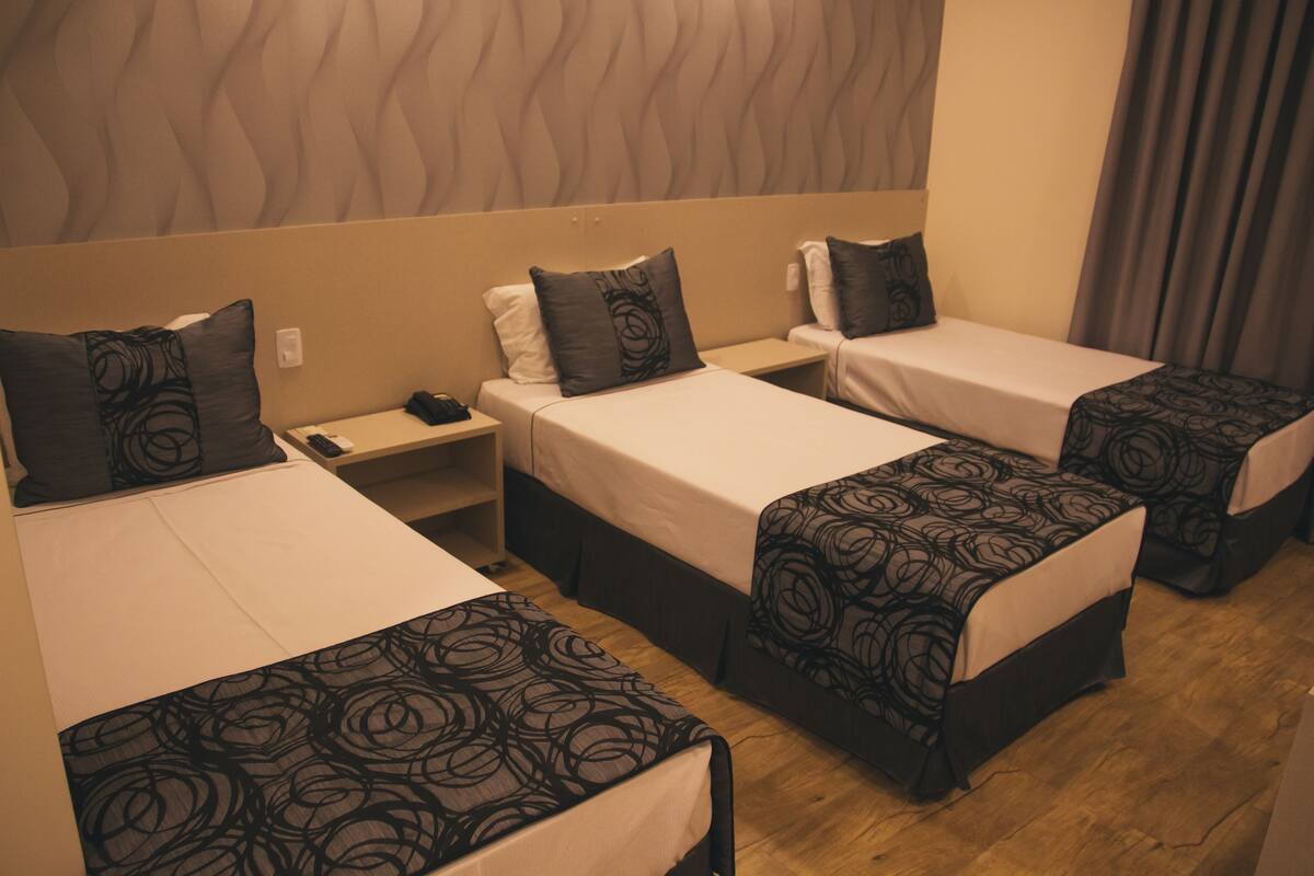 Deluxe Triple Room | Minibar, in-room safe, desk, blackout curtains