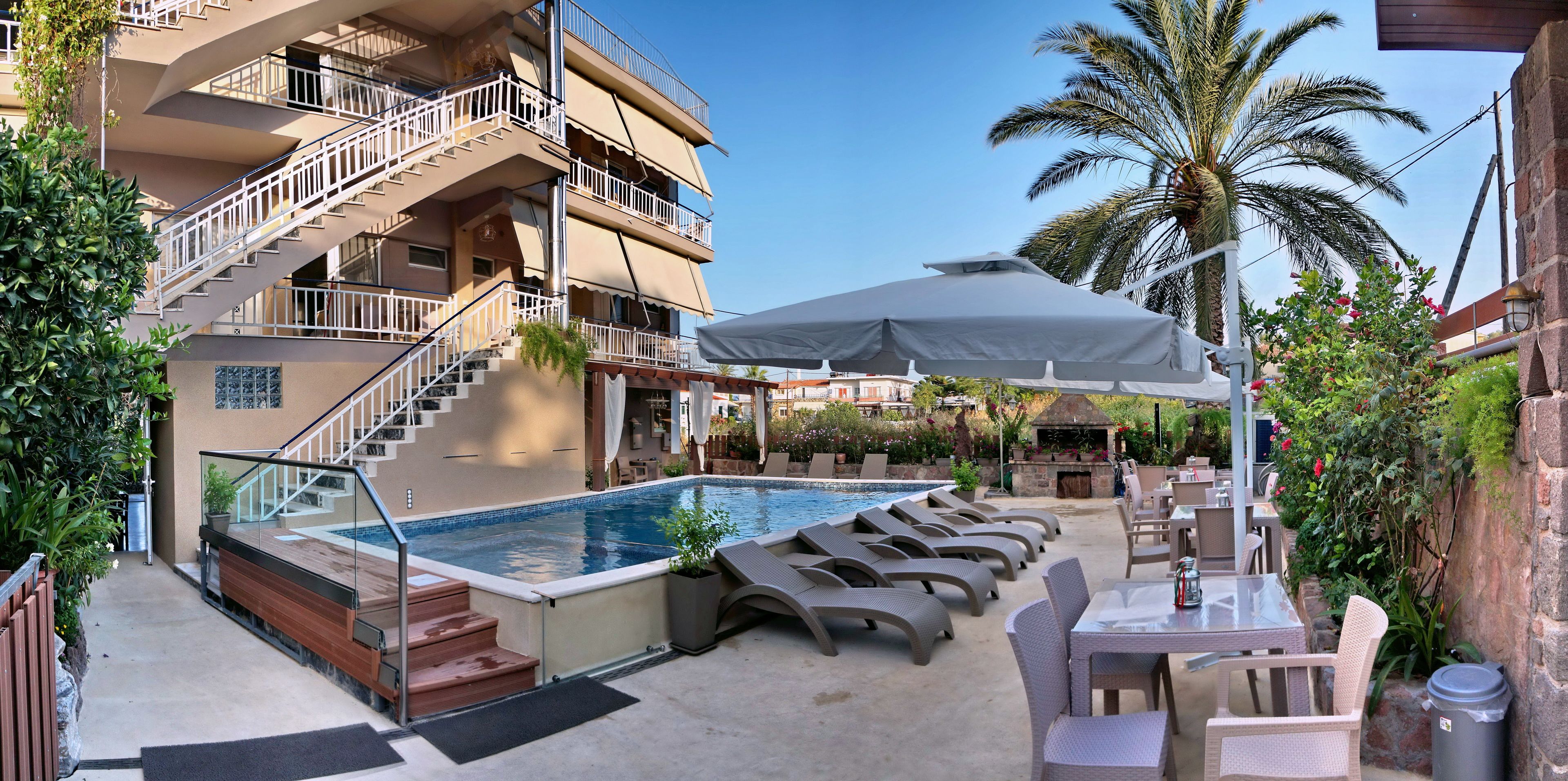 Un espace piscine aménagé sur le toit, avec des chaises longues et un barbecue.