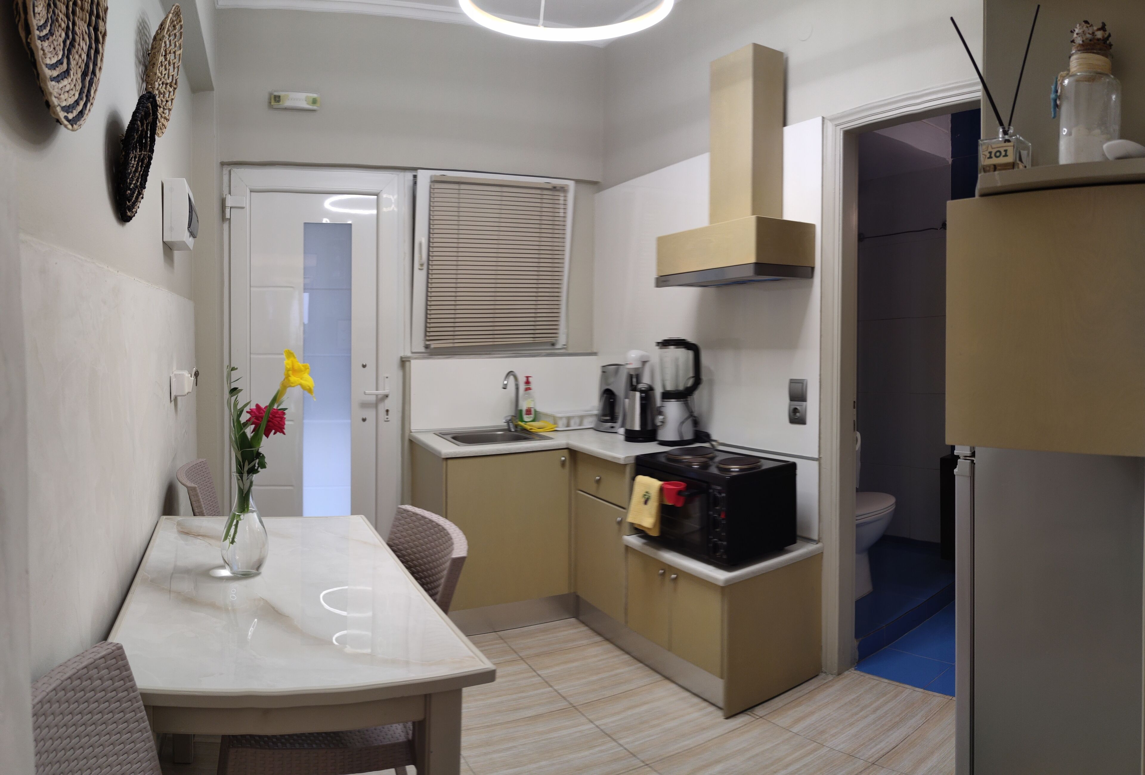 A compact kitchen with a dining table, a coffee maker, and a microwave.