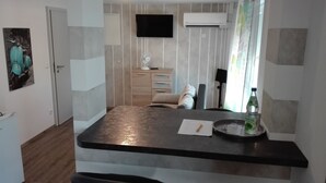 A modern kitchen with a black countertop, a sink, and a window with curtains. - Ferienwohnungen Paul und Dorothea (Döllstädt)