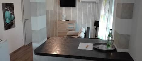 A modern kitchen with a black countertop, a sink, and a window with curtains.