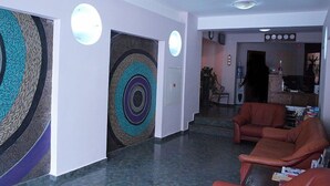 A modern lobby with a large abstract wall mural, leather seating, and a reception desk. - Rotasar Hotel (Sofia)