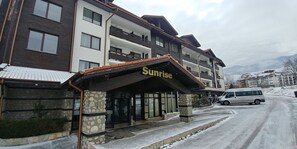 Et hotel med flere etager, en stenfacade og et skilt med teksten "Sunrise".