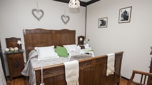 Une chambre à coucher avec un lit en bois, une table de chevet, une commode et une chaise.