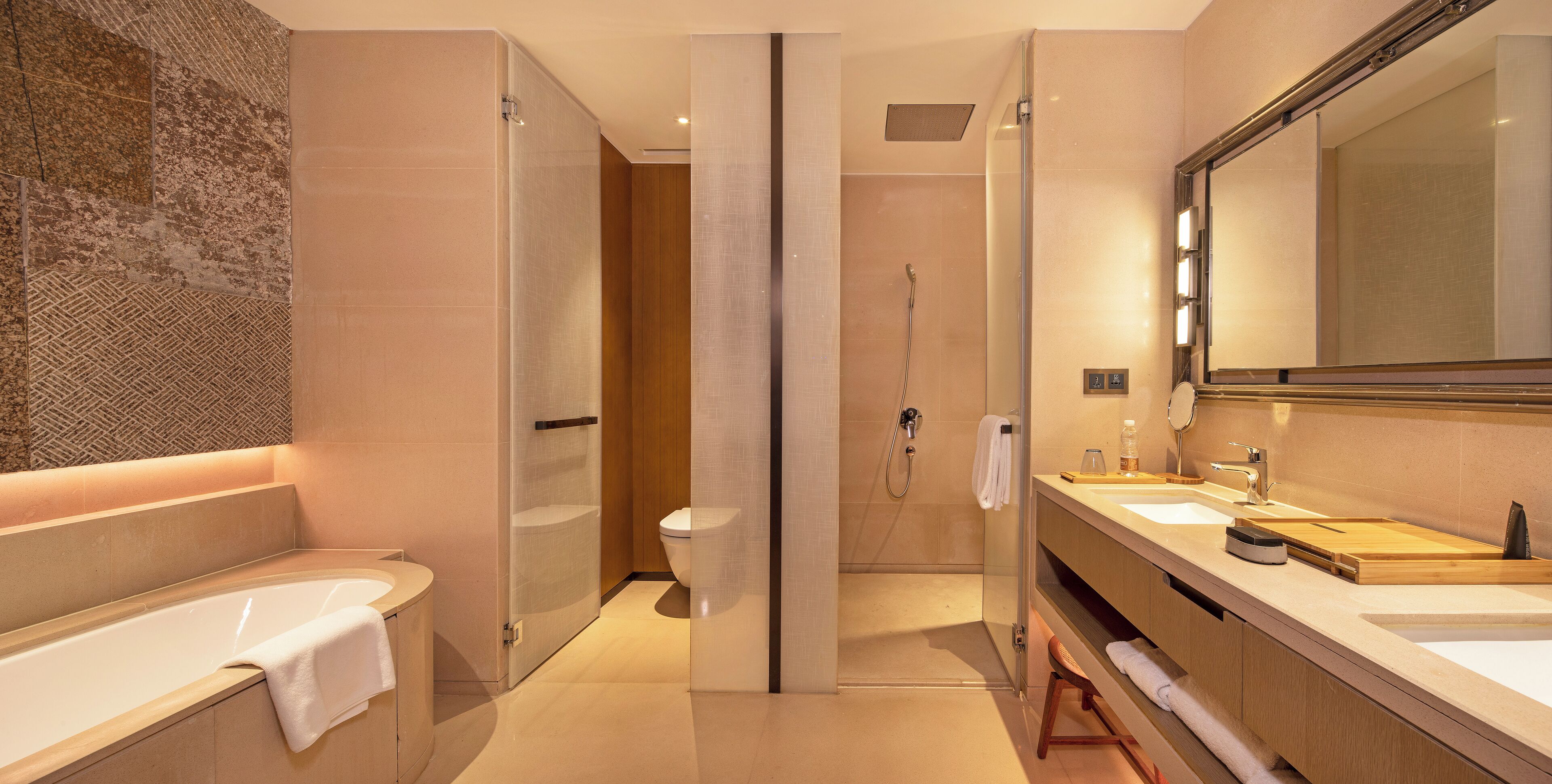 Ein modernes Badezimmer mit einer Badewanne, einer Dusche und einem Waschtisch mit Spiegel.