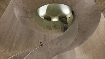 Una escalera de caracol dentro de una estructura de hormigón con un espacio abierto central.