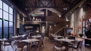 A spacious restaurant with high ceilings, exposed beams, and large windows offering views of the cityscape. - Yangshuo SugarHouse (Guilin)