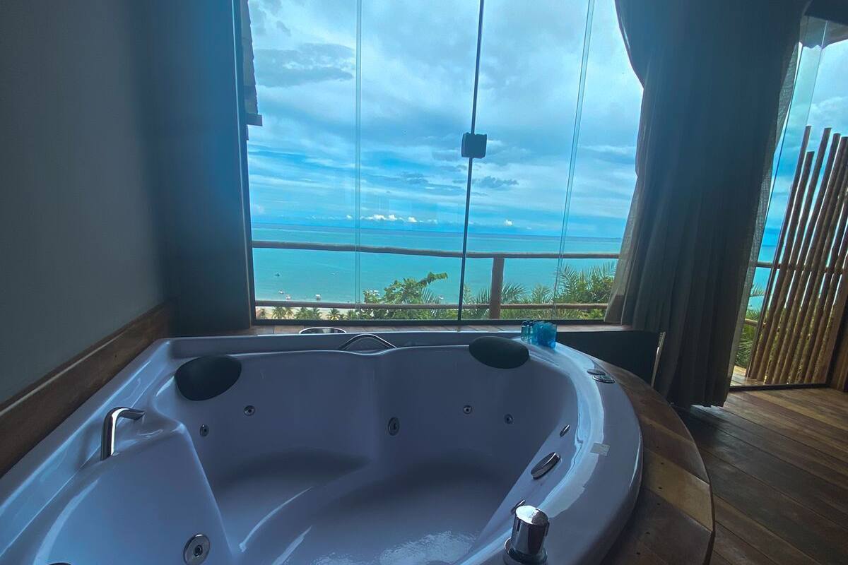 A large, empty bathtub in a room with a view of the ocean.