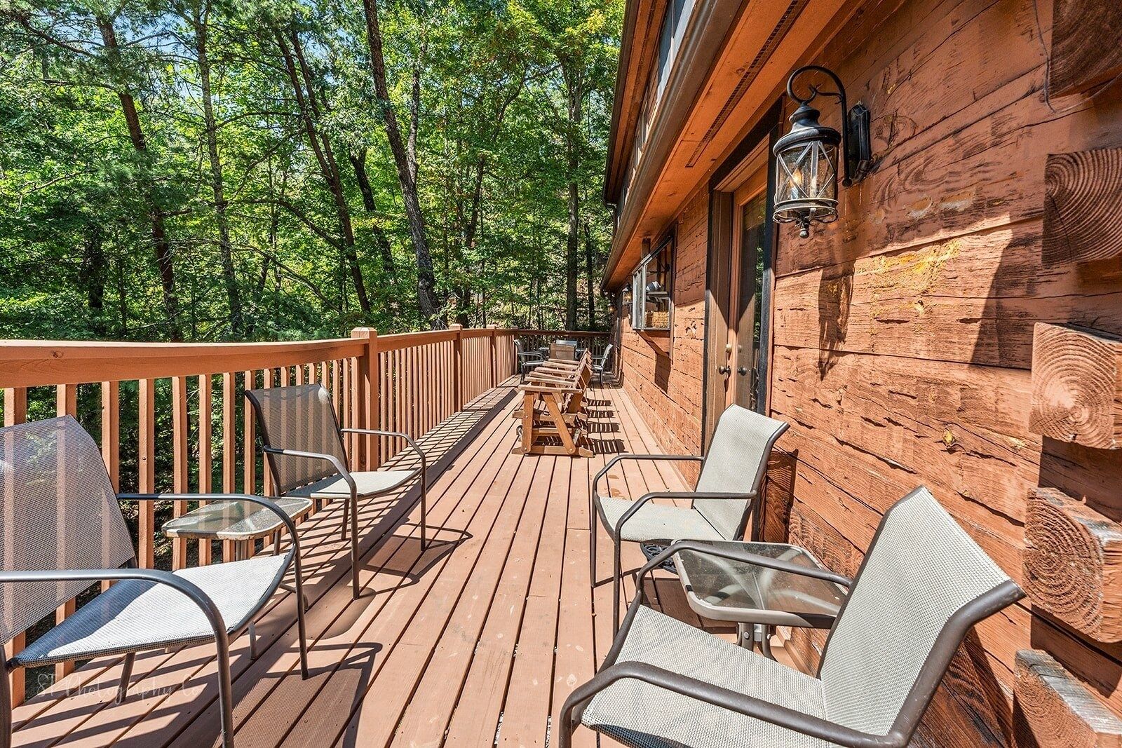 A wooden deck with outdoor seating and a lantern.