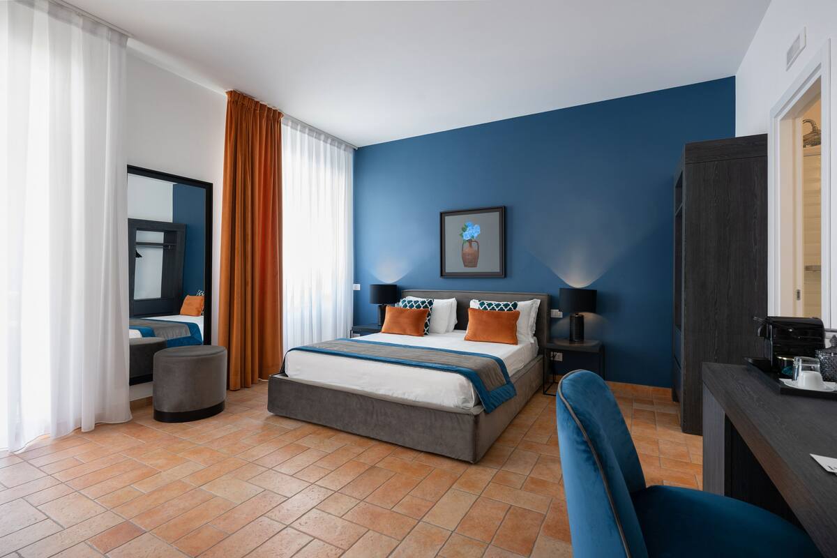Una habitación de hotel moderna con una cama grande, un escritorio y una silla.