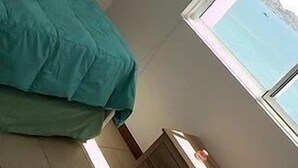 A small room with a bed, a wooden cabinet, and a window with a view. - Depto Costa Mansa (Coquimbo)