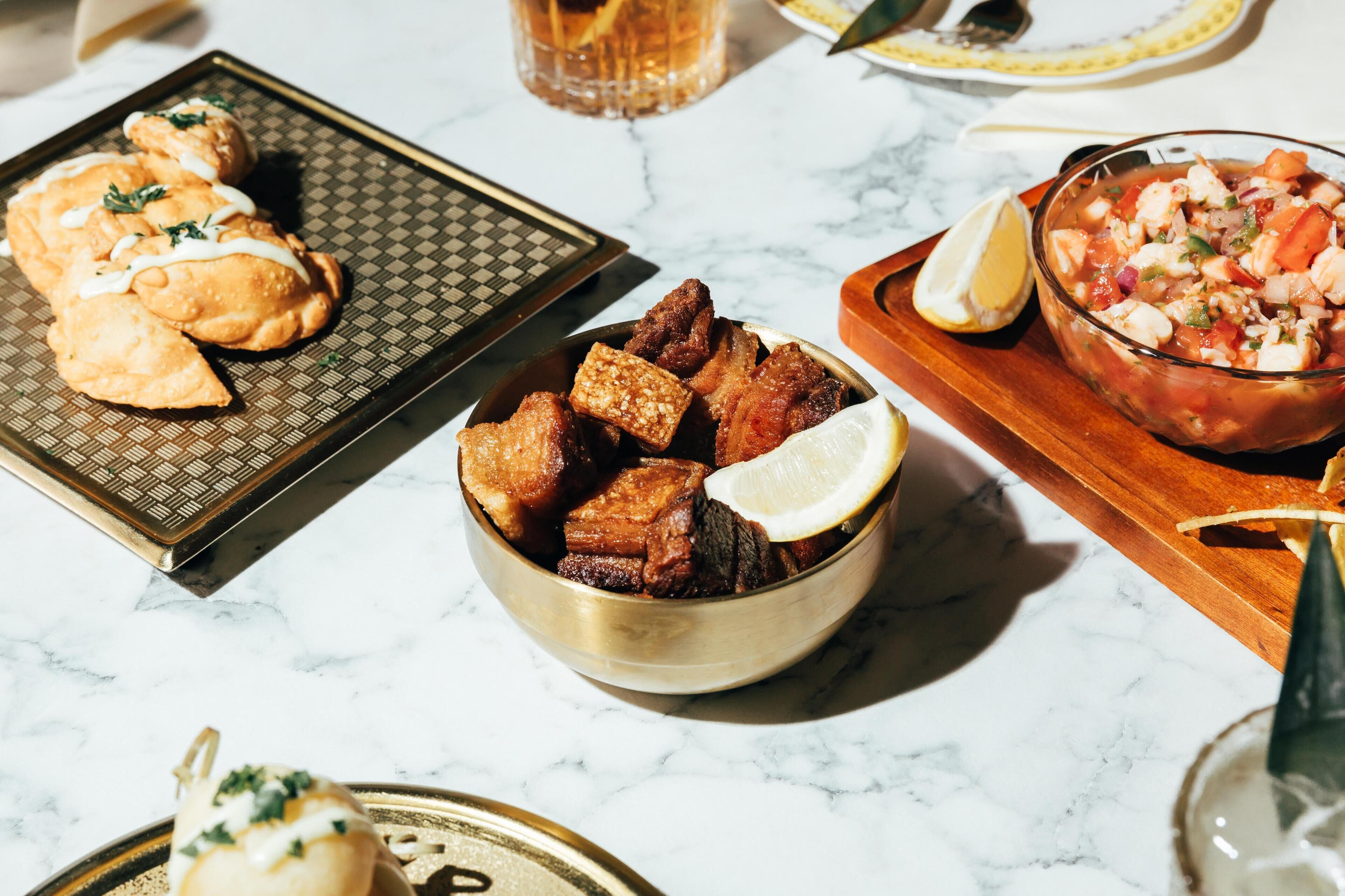 A table with various dishes, including fried items and a bowl of salad.