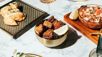 A table with various dishes, including fried items and a bowl of salad.