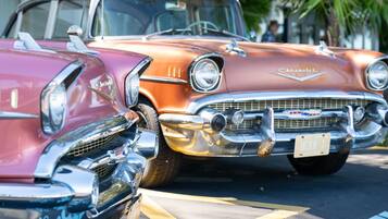 A vintage car with a chrome grille and emblem, parked on a street with yellow lines.