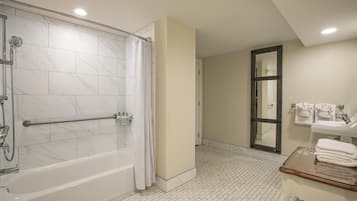 A bathroom with a bathtub, a shower, a sink, and a mirror.