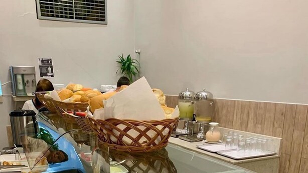 A buffet with various food items including bread, fruits, and prepared dishes.