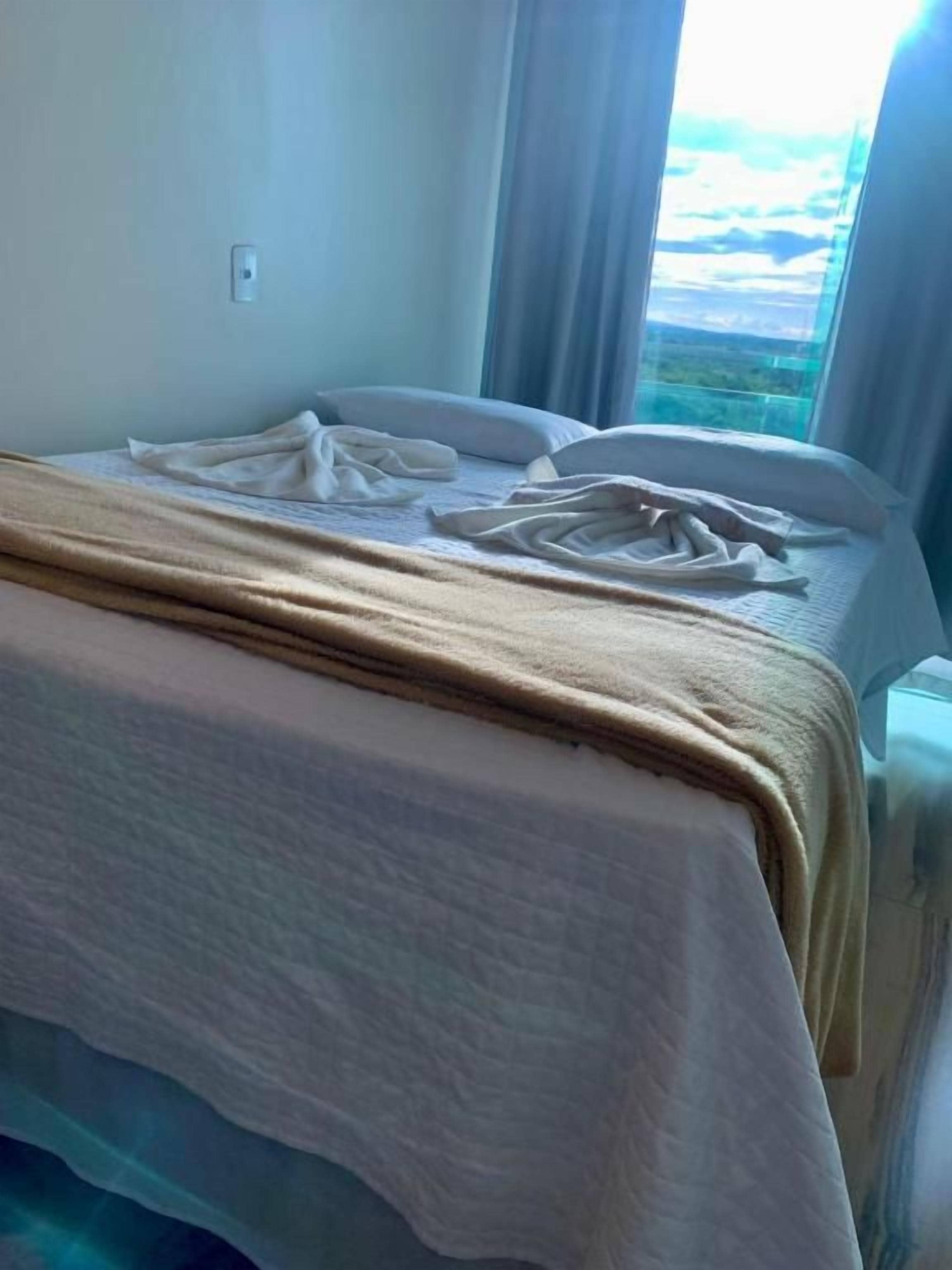 Una habitación de hotel con cama, ventana y vista al exterior.