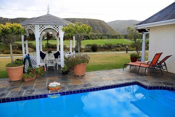 Una piscina al aire libre, tumbonas