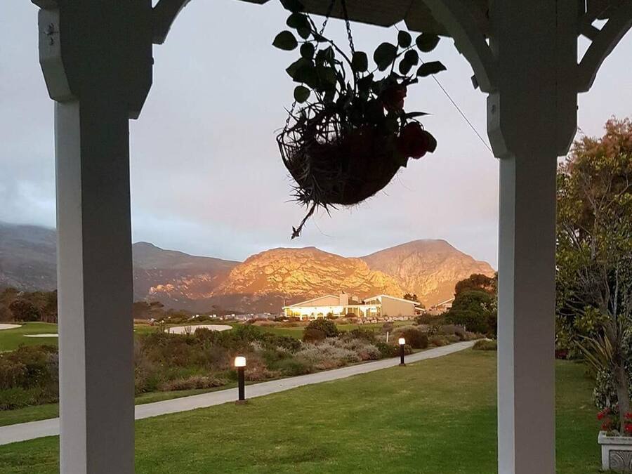 A gazebo with a view of a mountain and a building in the distance.