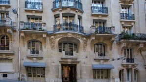 A historic building with ornate balconies, large arched windows, and a grand entrance. - CMG Tour Eiffel (Paris)