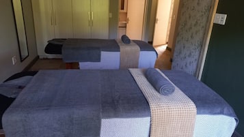 Relax in this serene space with two massage therapy beds, each covered in a textured blanket.