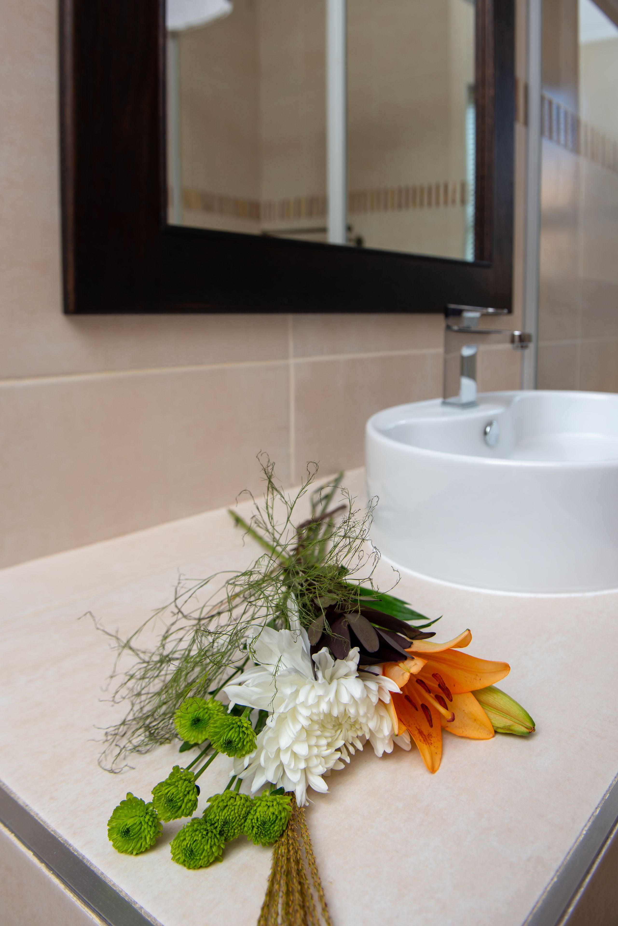 A bathroom with a white sink and a mirror above it.