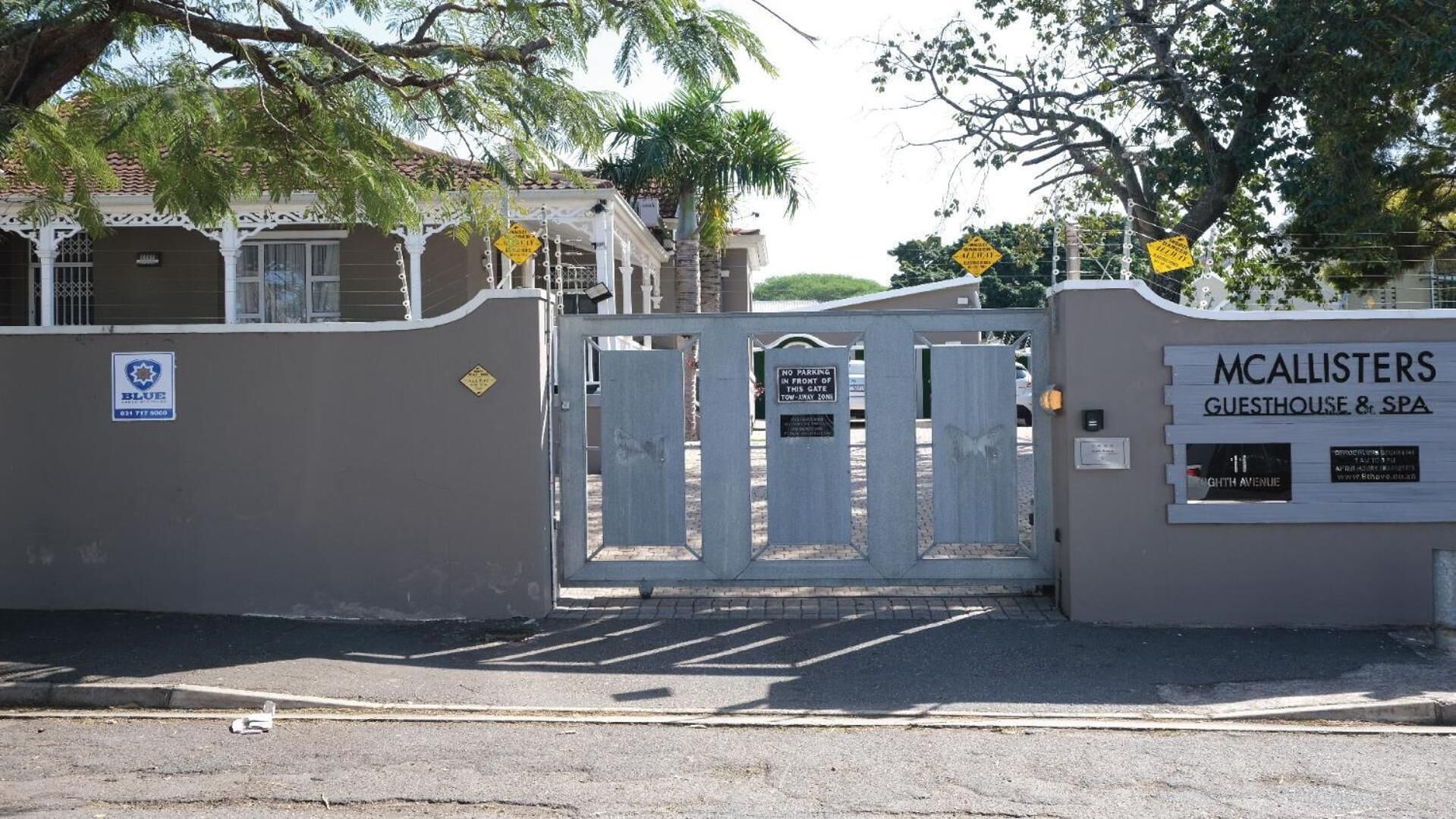A gated entrance to a property named 'McAllisters Guesthouse & Spa' with a sign indicating 'No Parking in Front of This Gate'.
