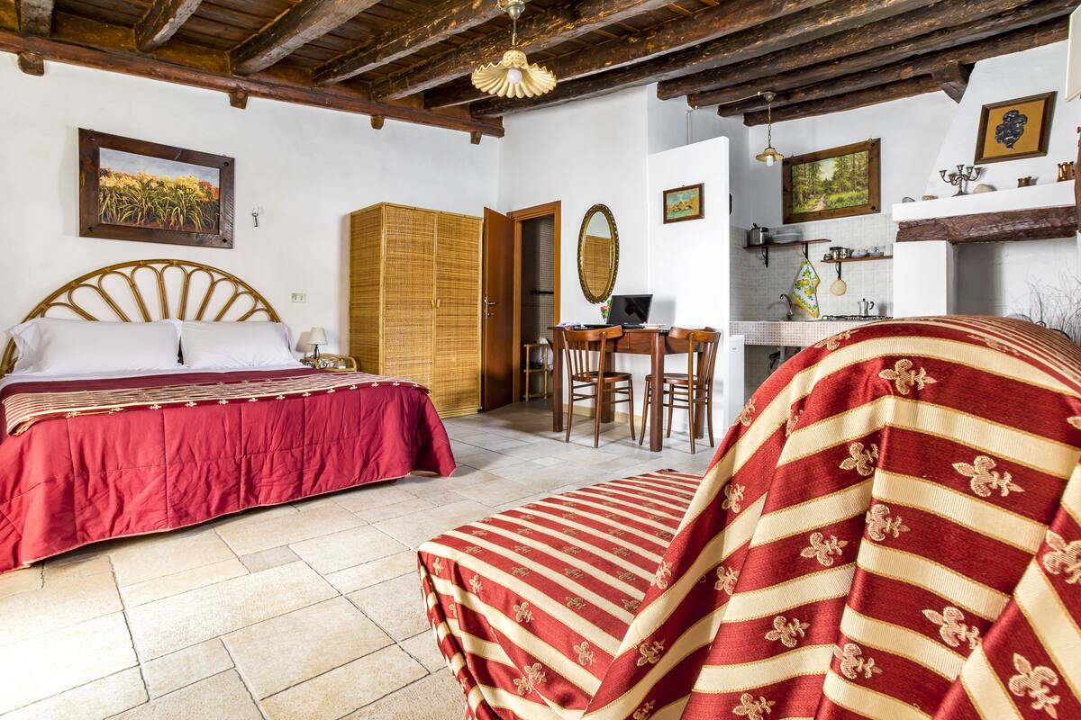 Un dormitorio con una cama, una silla, un escritorio y un armario.