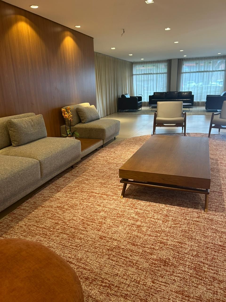 Una sala de estar moderna con un sofá, sillones y una mesa de centro.