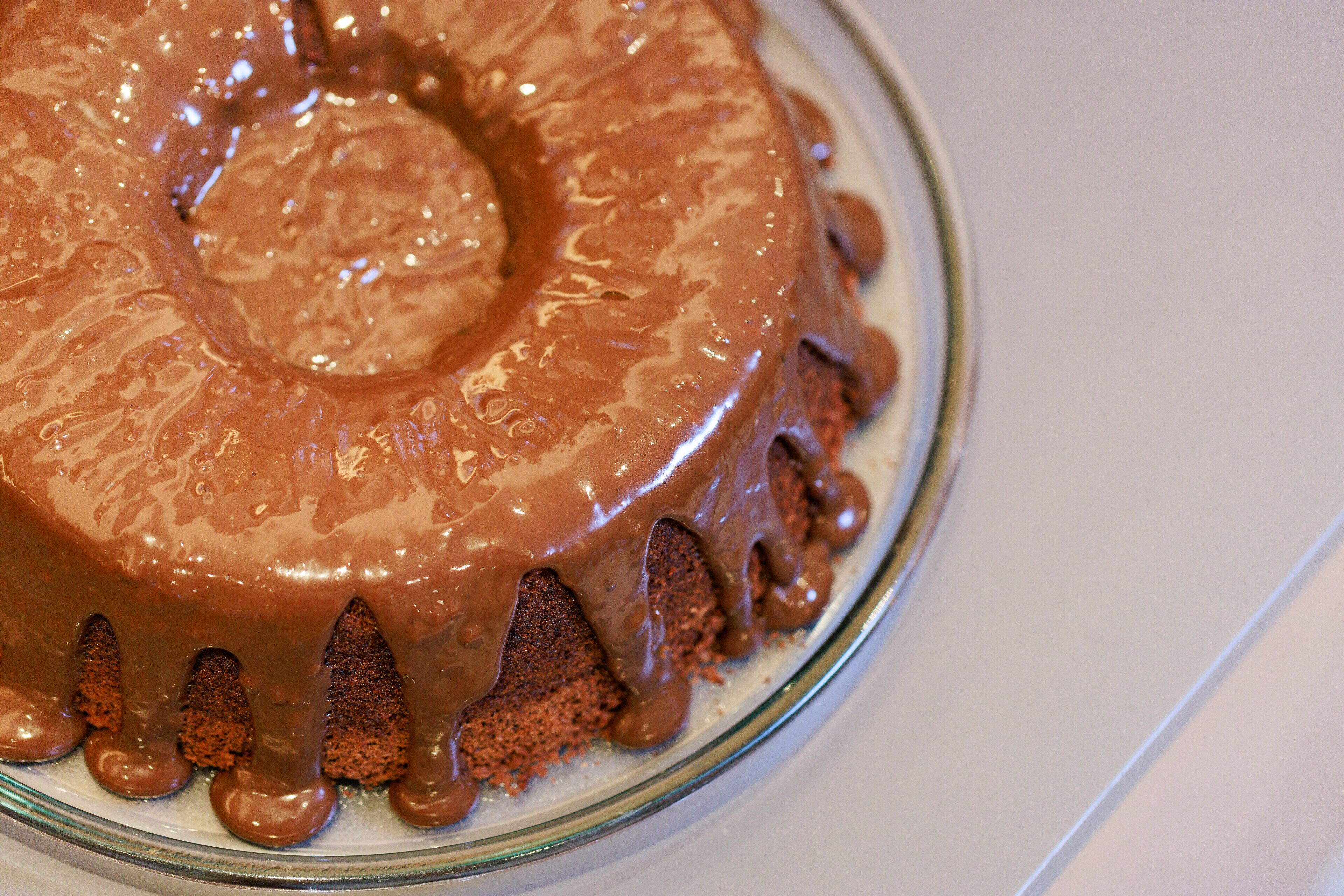 A chocolate cake with a glossy finish and a decorative edge.