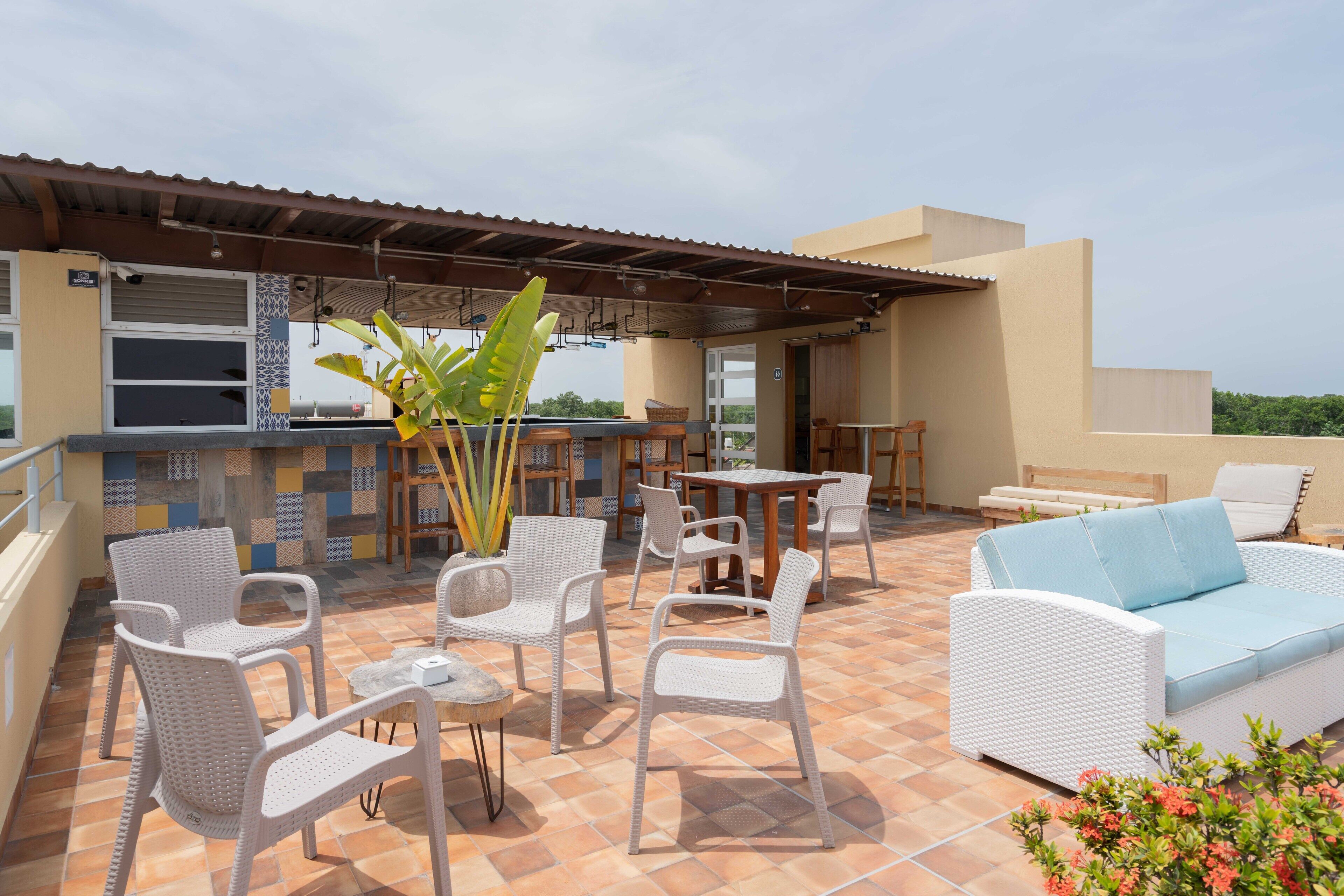 A patio area with outdoor furniture, a bar, and a view of the surrounding landscape.
