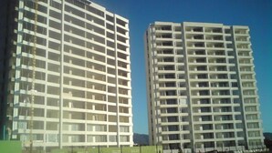 Two high-rise buildings with multiple floors, each featuring a grid-like structure of windows and balconies. - Depto Claudia Peñuelas (Coquimbo)