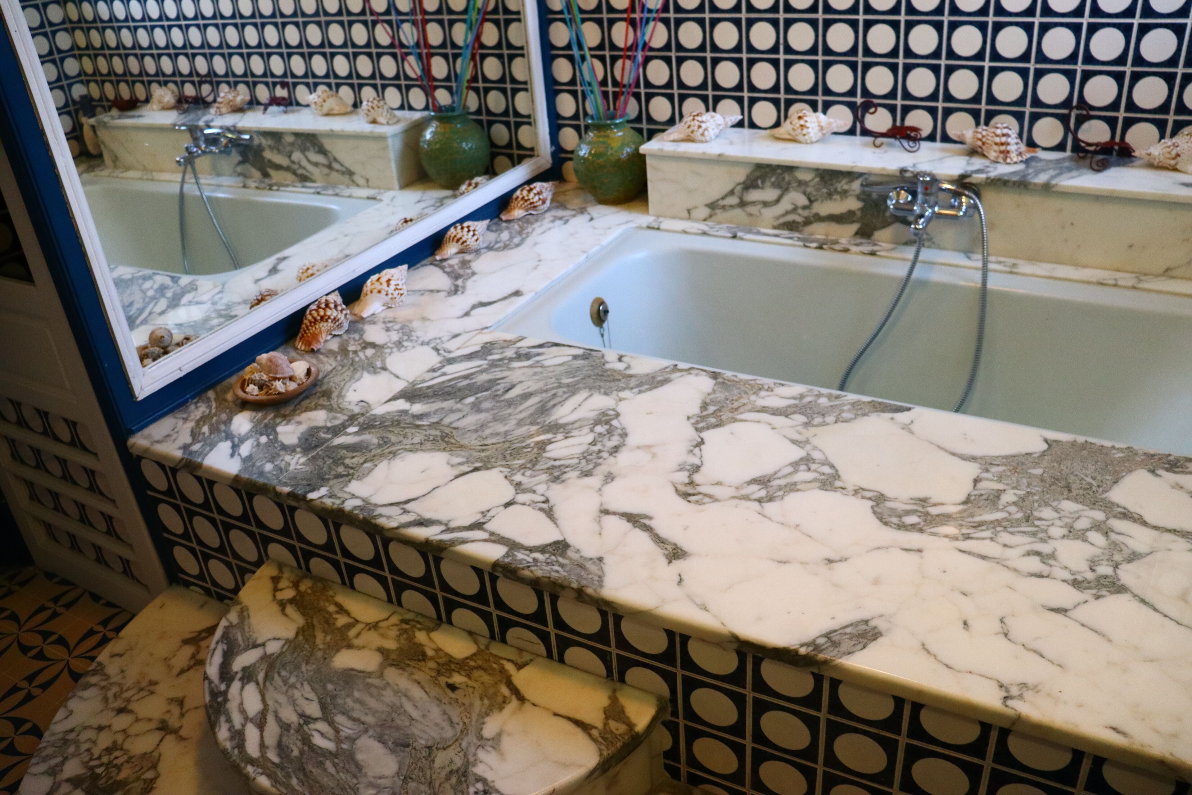 Ein Badezimmer mit Marmorplatte, zwei Waschbecken und einem Spiegel.