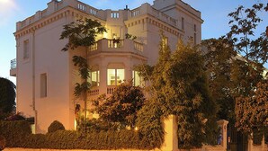Um edifício grande e imponente, com vários andares, fachada simétrica, janelas amplas e entrada central.