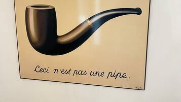 A framed artwork of a smoking pipe with the text "Ceci n'est pas une pipe."