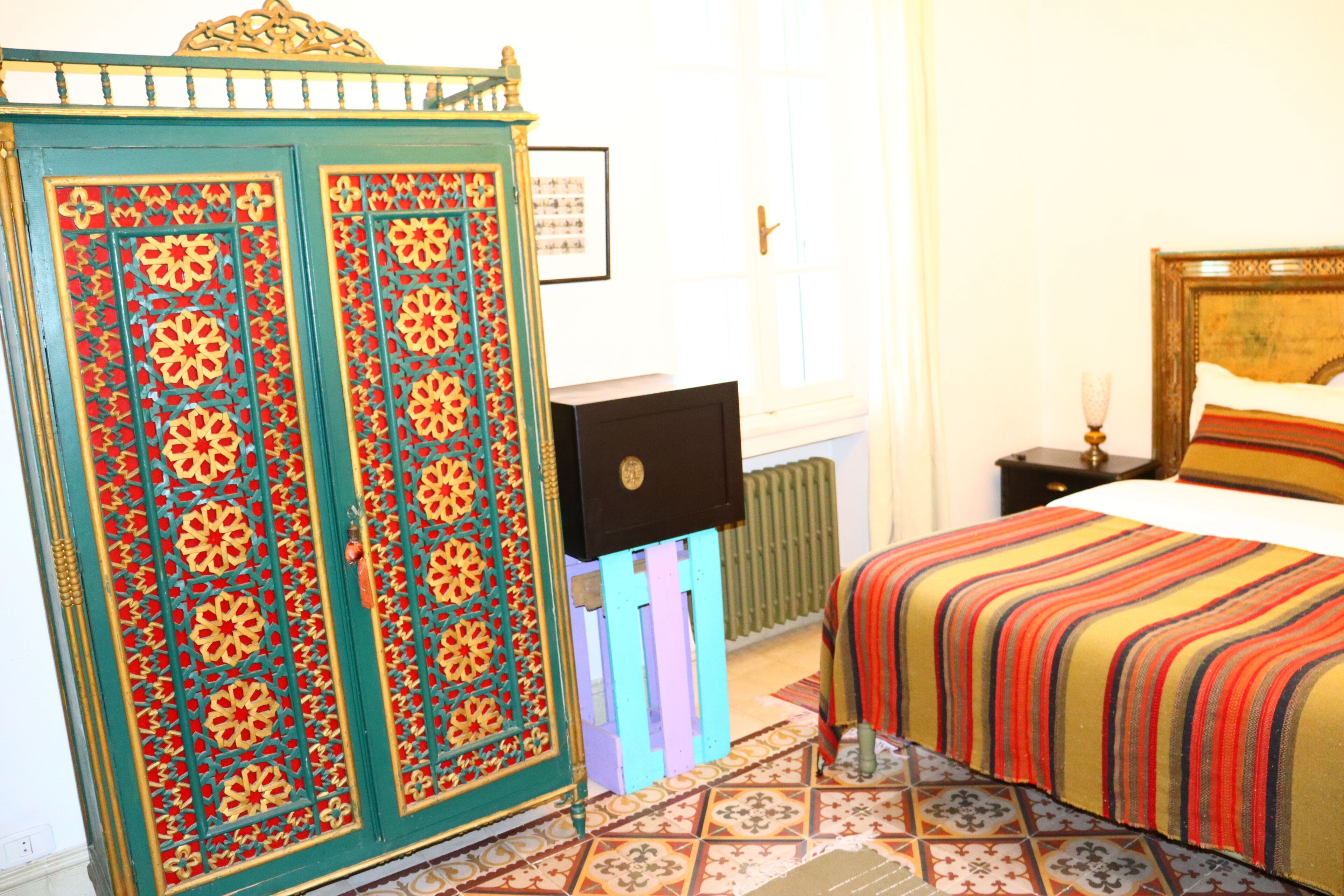 Un dormitorio con cama, armario y radiador.