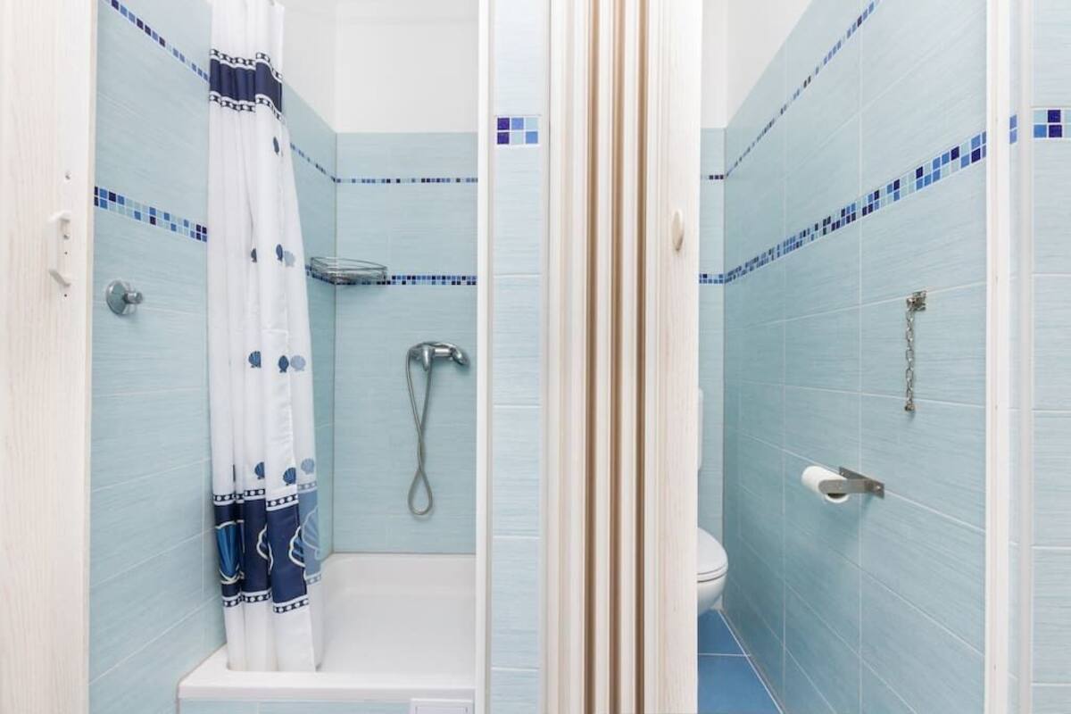 A bathroom with a shower, toilet, and bathtub.