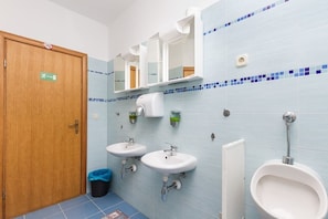 A public restroom with two sinks, a urinal, and a mirror above the sinks. - Hostel Oktarin (Kastela)