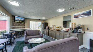 A modern kitchen with a bar area, seating, and a TV.