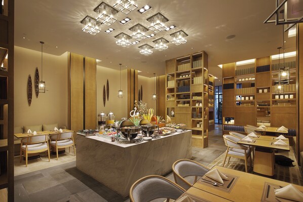 A hotel lobby with a central reception desk, seating areas, and a large bookshelf. - Crowne Plaza Nanchang Wanli by IHG (Nanchang)