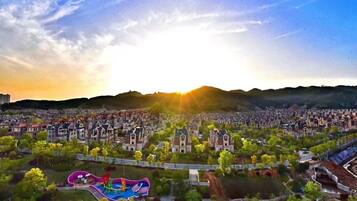 A residential area with a large park featuring a colorful playground and a water slide.